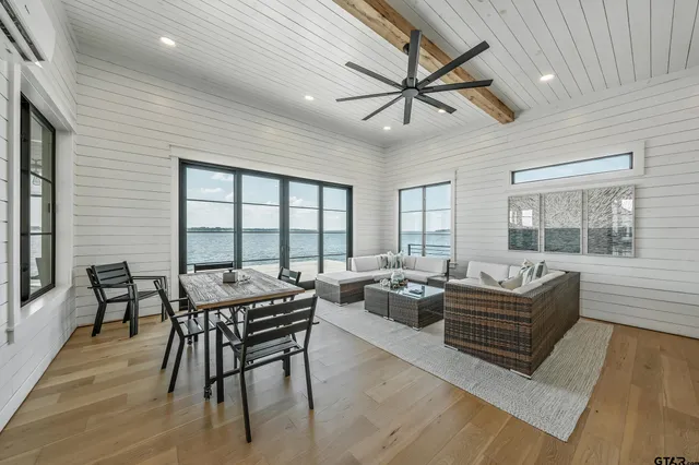 a living room with furniture ceiling fan and a large window