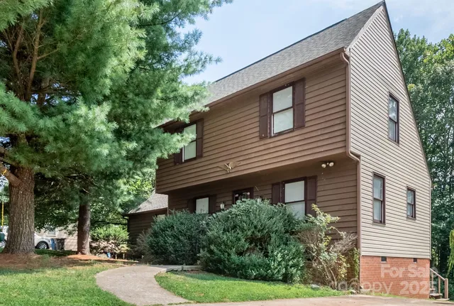 a view of a house with a yard and potted plants