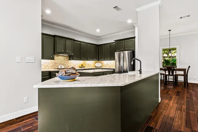 a kitchen with stainless steel appliances granite countertop a sink a stove and refrigerator