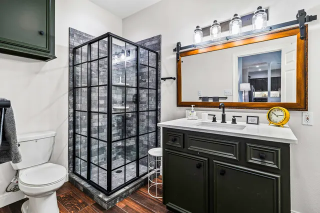 a bathroom with a sink a toilet and shower