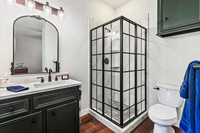 a bathroom with a granite countertop sink mirror vanity and toilet