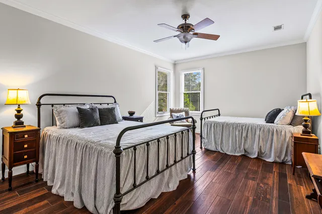 a bedroom with three beds and wooden floor
