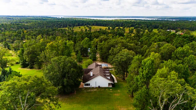 an aerial view of a house with a yard and lake view