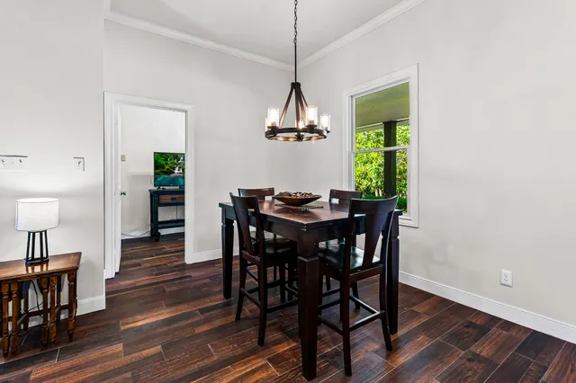 a dining room with furniture a chandelier and wooden floor