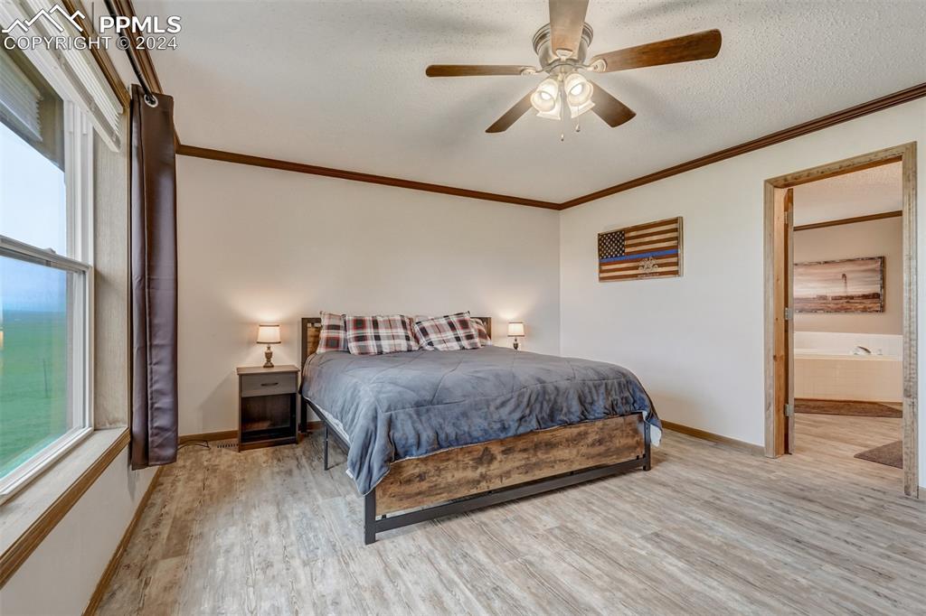 21445 Scott Road Calhan, CO 80808 - Photo 18 of 50 a spacious bedroom with a bed and a chandelier