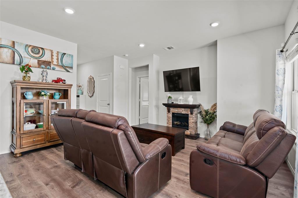 409 Wilson Way Denton, TX 76207 - Photo 7 of 33 Living area featuring wood-finish flooring, recessed lighting, a stone-faced fireplace with a dark wood mantel, and white interior doors
