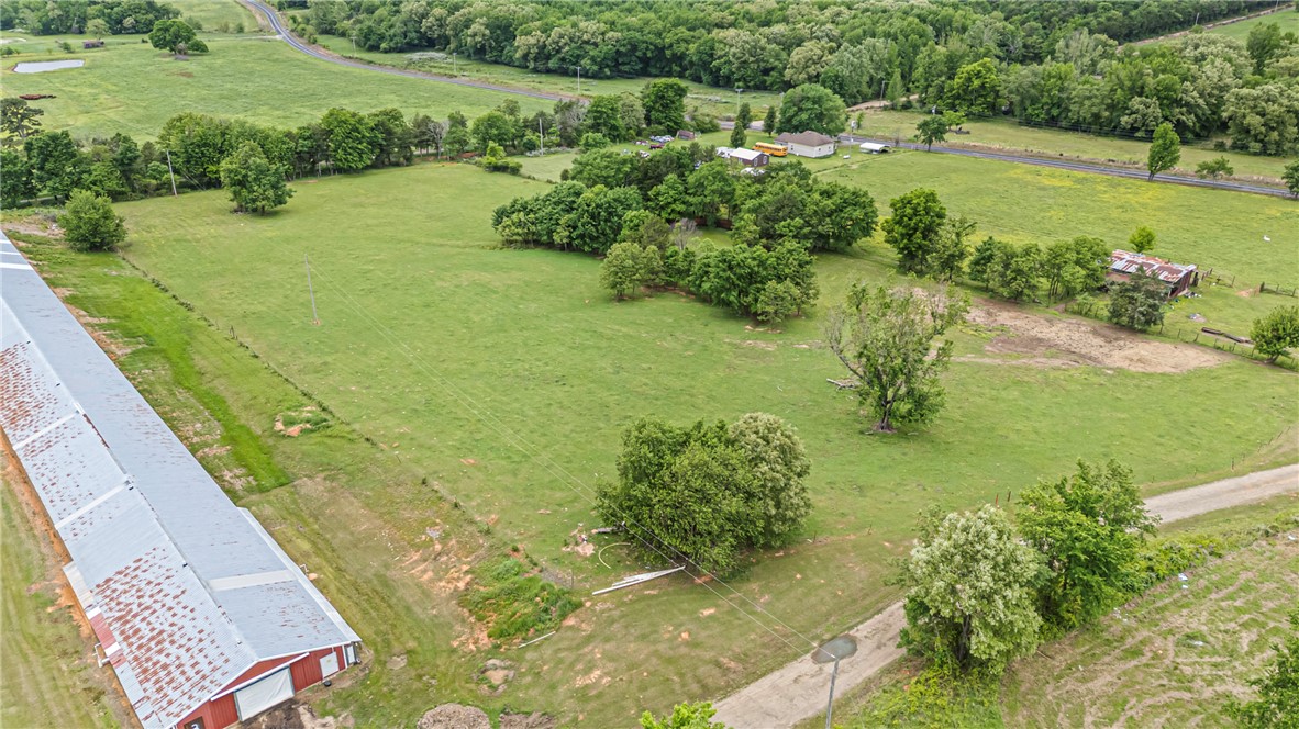 0 Wire Road Mulberry, AR 72947 - Photo 11 of 31 Expansive green acreage featuring multiple mature trees and a substantial red-sided building with a metal roof