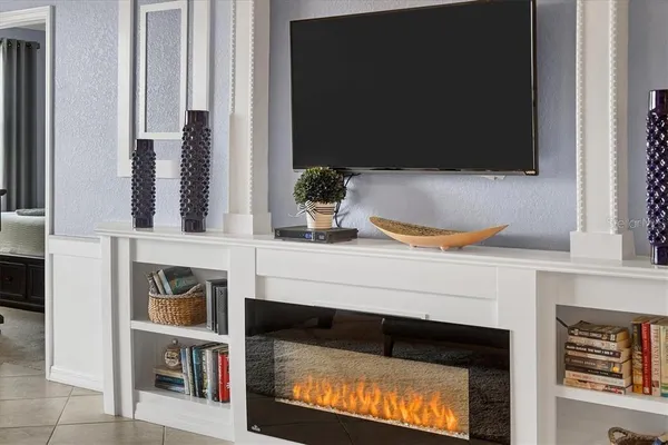 a living room with a fireplace and a flat screen tv