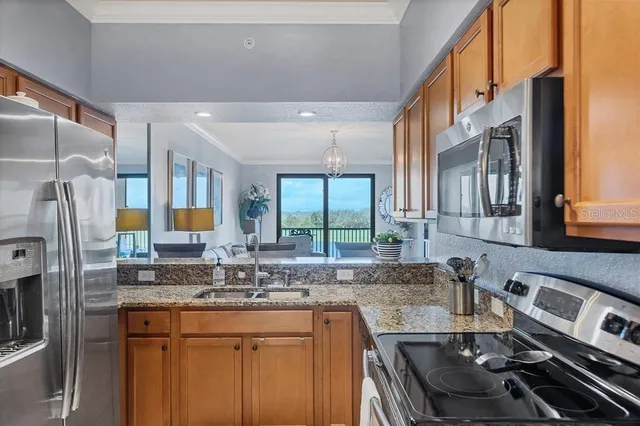 a kitchen with stainless steel appliances granite countertop a sink stove and refrigerator