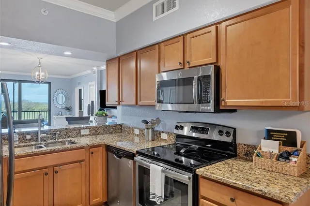 a kitchen with stainless steel appliances granite countertop a stove a sink and a microwave