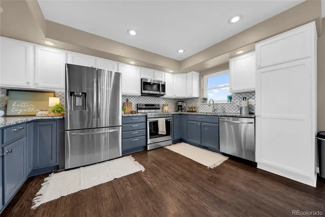 a kitchen with a refrigerator a sink a stove a microwave and wooden cabinets