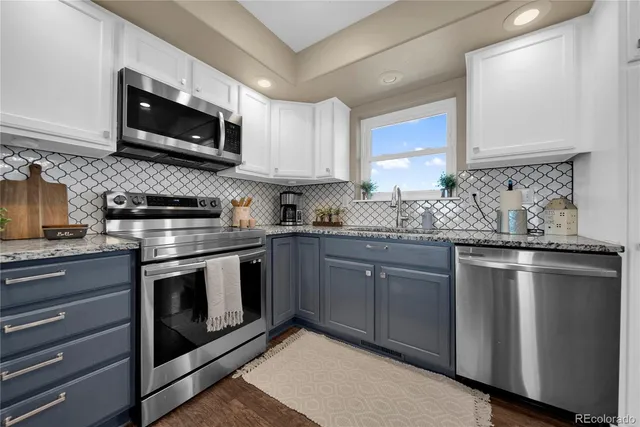 a kitchen with stainless steel appliances granite countertop a stove microwave and sink