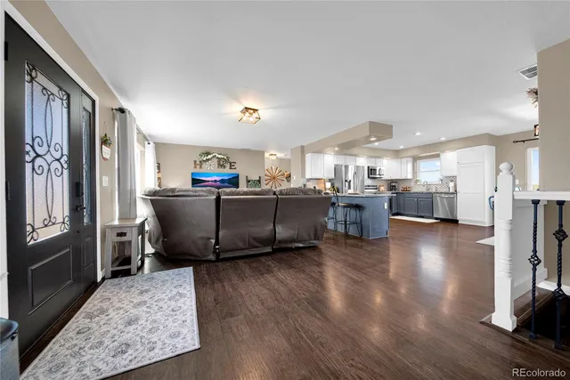 a living room with furniture and a wooden floor