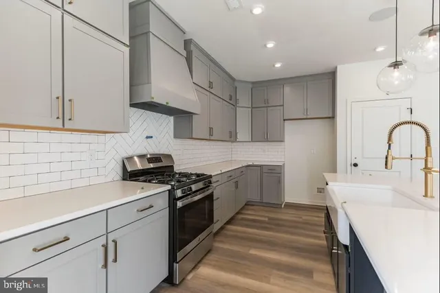 a kitchen with stainless steel appliances granite countertop a sink a stove and a refrigerator