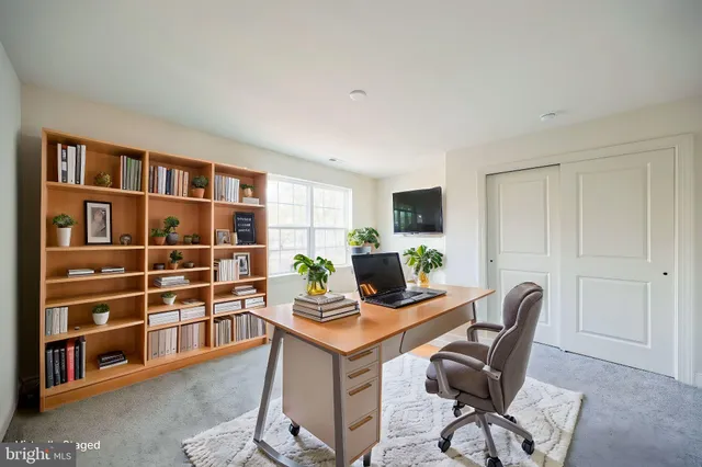 a view of a workspace with furniture and a window