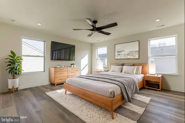 a spacious bedroom with a bed and a flat screen tv