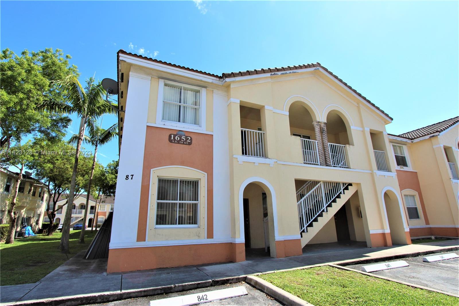 1652 Southeast 28th Street, Unit 105 Homestead, FL 33035 - Photo 1 of 18 a front view of a house with a yard