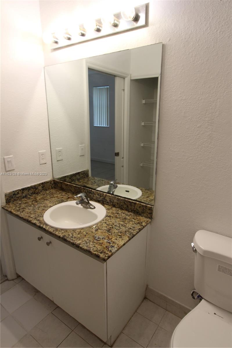 1652 Southeast 28th Street, Unit 105 Homestead, FL 33035 - Photo 11 of 18 a bathroom with a granite countertop sink and a mirror