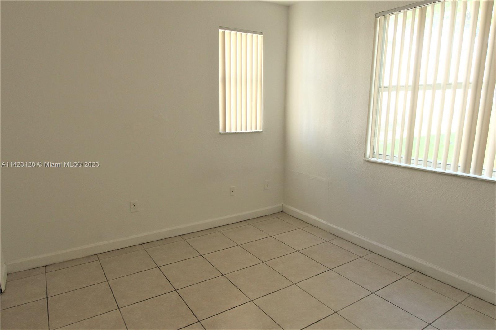 1652 Southeast 28th Street, Unit 105 Homestead, FL 33035 - Photo 12 of 18 an empty room with windows