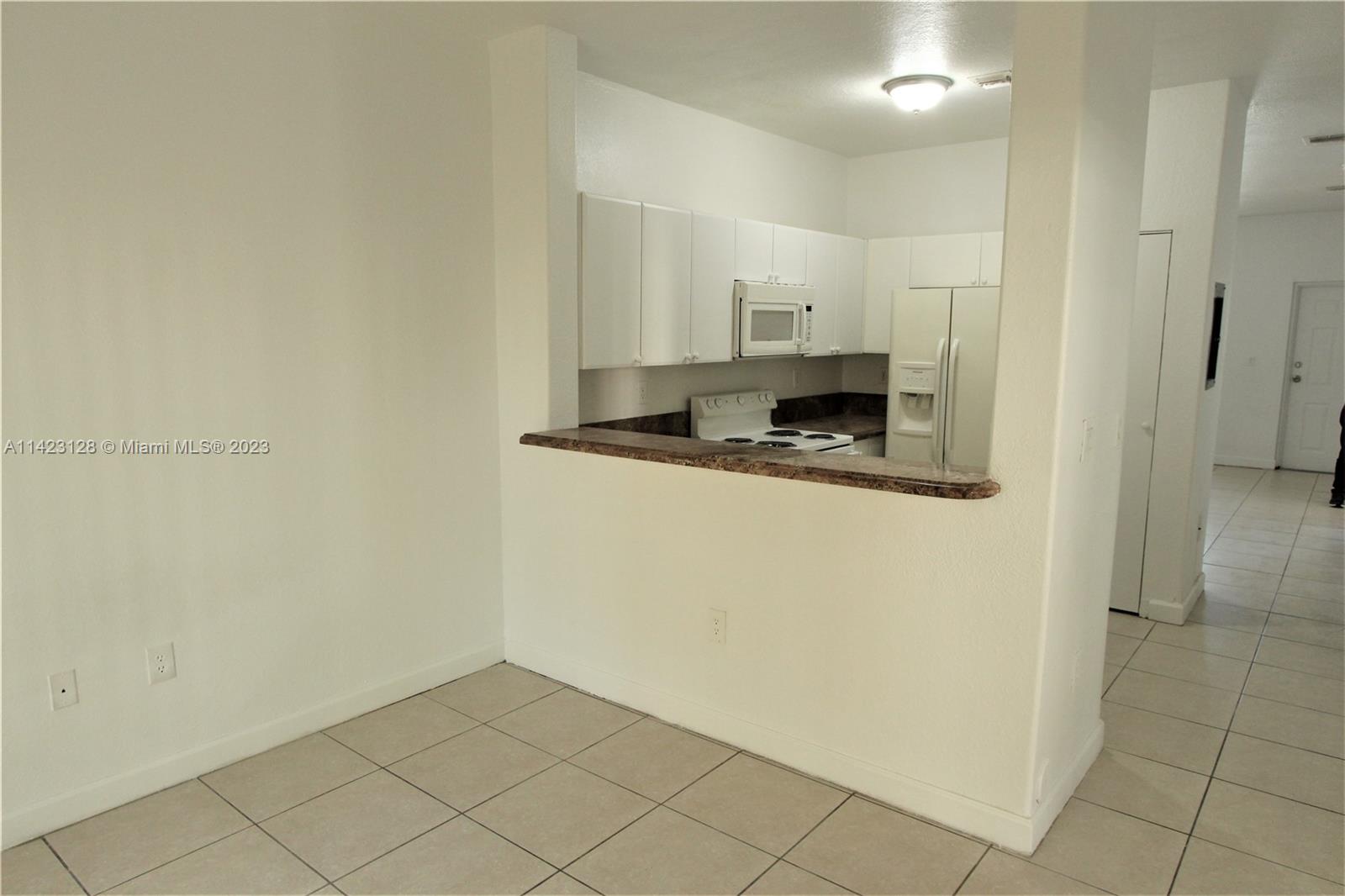 1652 Southeast 28th Street, Unit 105 Homestead, FL 33035 - Photo 3 of 18 a kitchen with stainless steel appliances a sink and a refrigerator