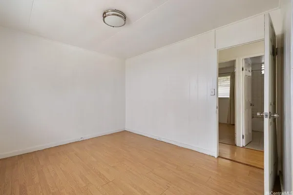 a view of a room with wooden floor and mirror