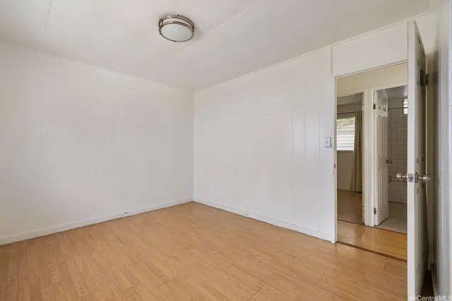 a view of a room with wooden floor and mirror