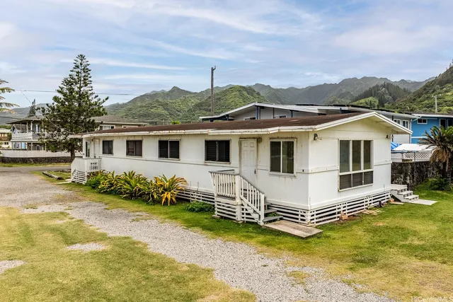 a white house covered with tall trees