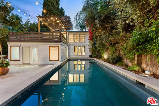 a view of a house with pool and sitting area