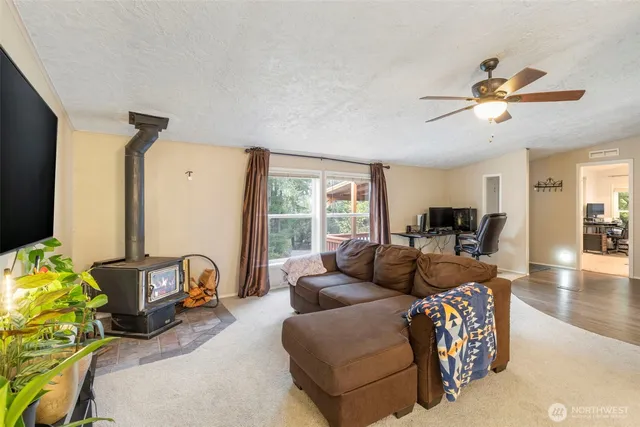 a living room with furniture a flat screen tv and a large window