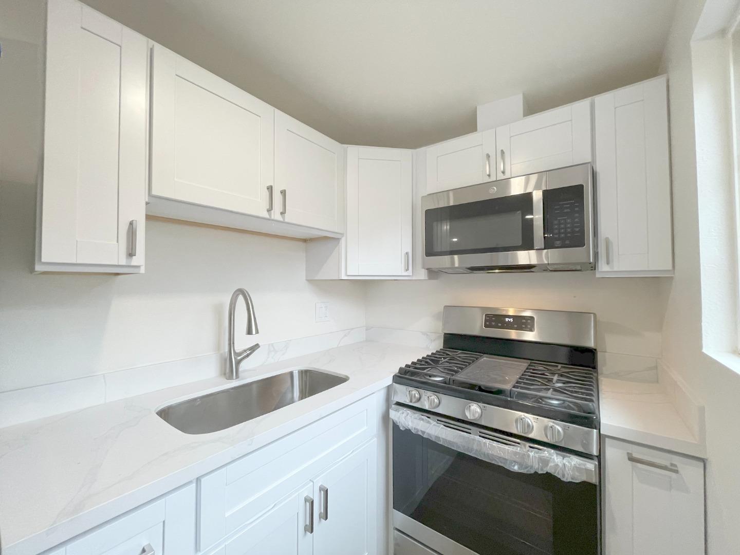 1758 5th Street, Unit STUDIO Livermore, CA 94550 - Photo 5 of 6 a kitchen with stainless steel appliances granite countertop a sink a stove a microwave and cabinets