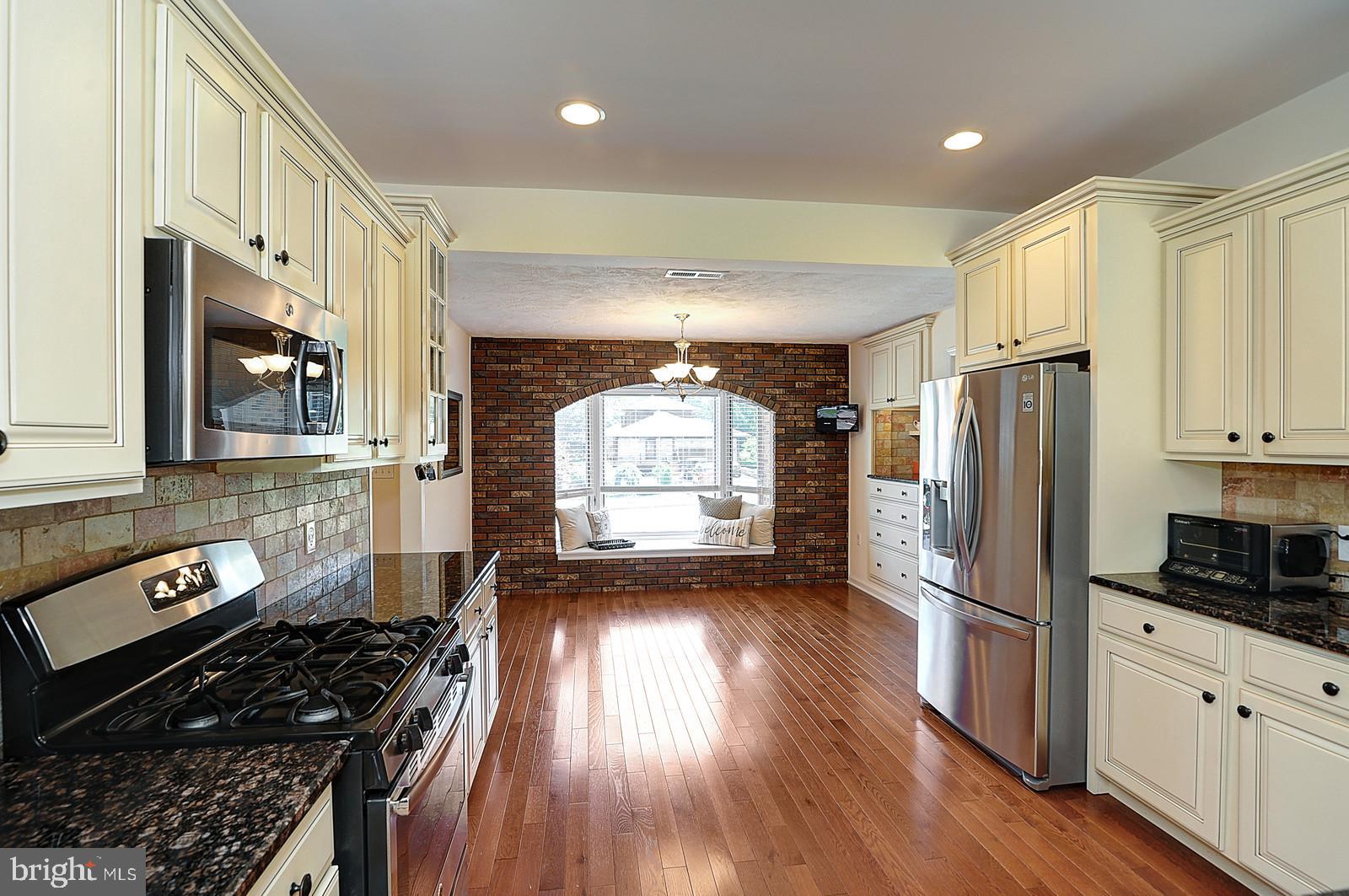 1 Cavalier Drive Hamilton, NJ 08619 - Photo 5 of 44 a kitchen with granite countertop a stove a sink a refrigerator and wooden floor