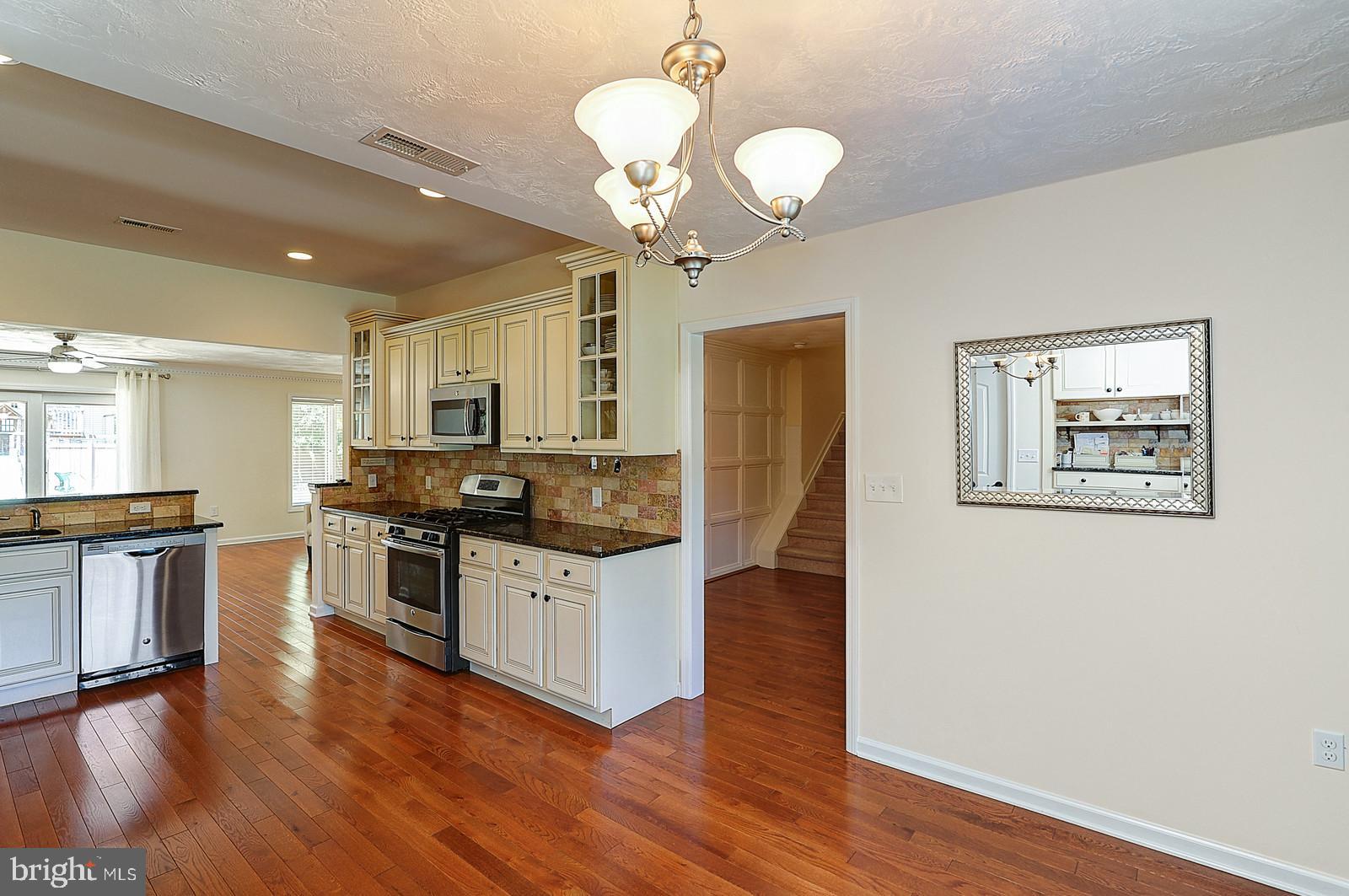 1 Cavalier Drive Hamilton, NJ 08619 - Photo 8 of 44 a kitchen with granite countertop a stove top oven a sink dishwasher and wooden floor
