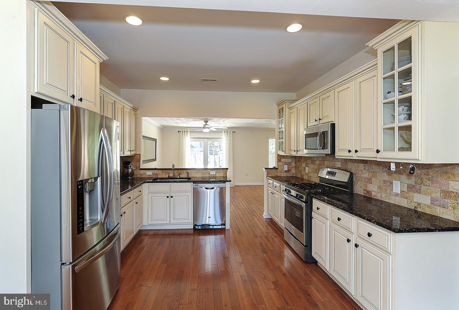 1 Cavalier Drive Hamilton, NJ 08619 - Photo 9 of 44 a large kitchen with stainless steel appliances granite countertop a stove a sink dishwasher a refrigerator and white cabinets with wooden floor