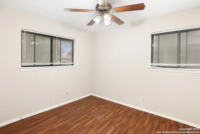 an empty room with a window and wooden floor
