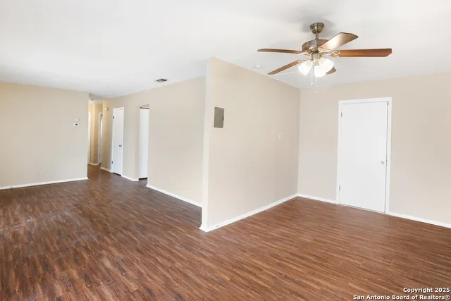 a view of an empty room with wooden floor