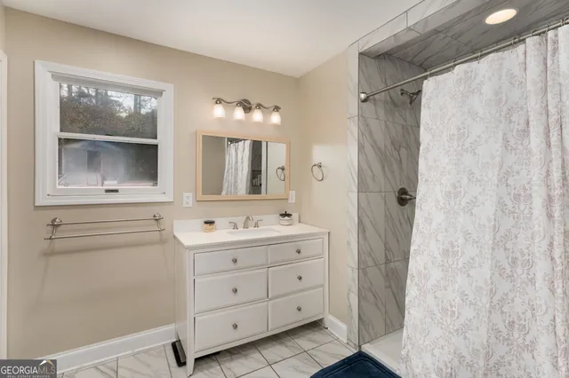 a bathroom with a double vanity sink a mirror a vanity and a shower