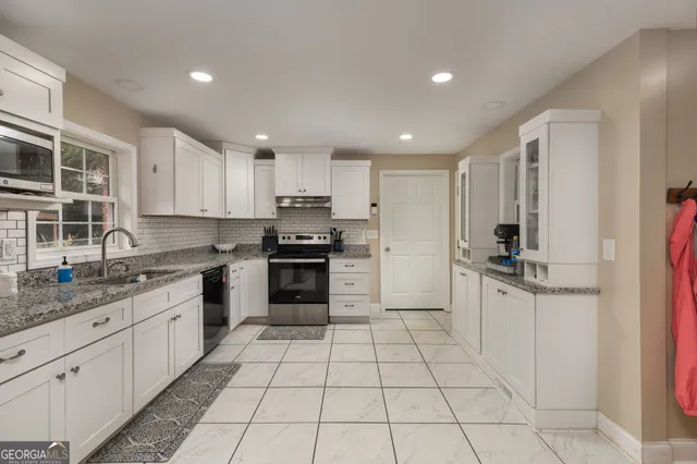 a kitchen with stainless steel appliances granite countertop a refrigerator and a sink