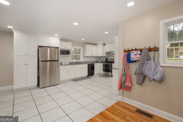 a kitchen with stainless steel appliances granite countertop a refrigerator and a sink