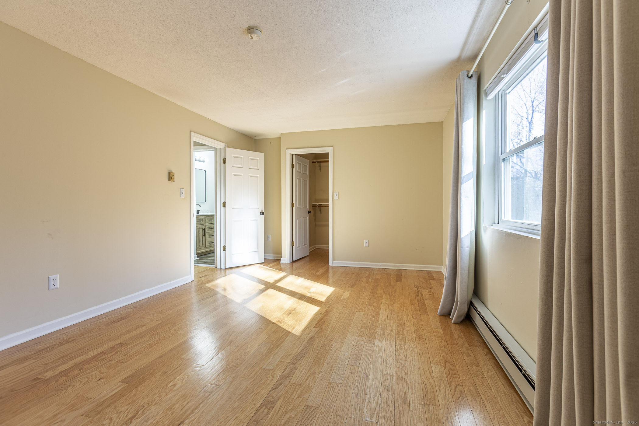 187 Lovers Lane, Unit 61 Torrington, CT 06790 - Photo 15 of 29 a view of an empty room with wooden floor and a window