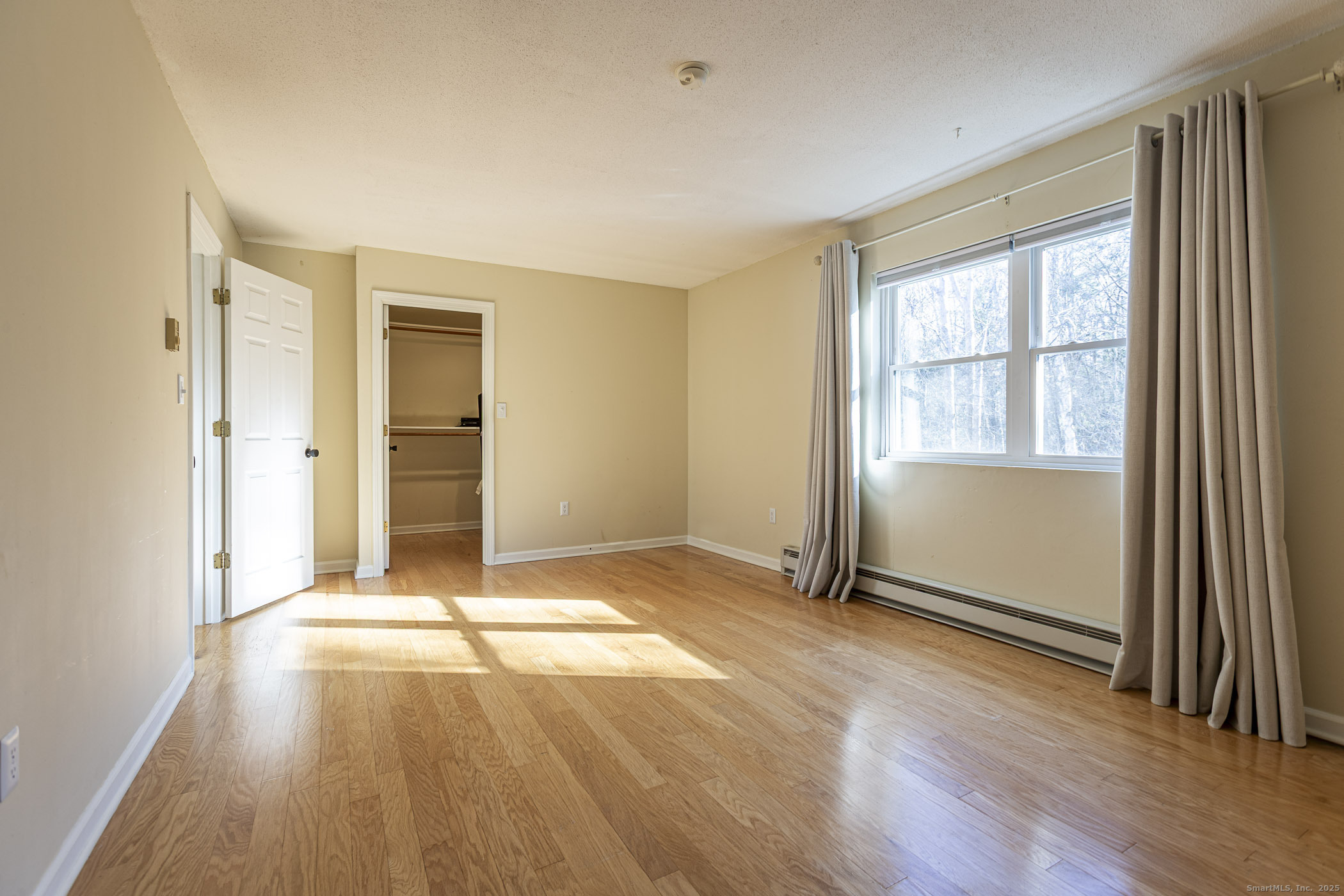 187 Lovers Lane, Unit 61 Torrington, CT 06790 - Photo 17 of 29 an empty room with wooden floor and windows