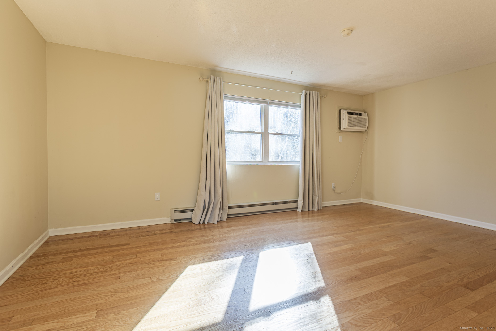 187 Lovers Lane, Unit 61 Torrington, CT 06790 - Photo 18 of 29 an empty room with wooden floor and windows