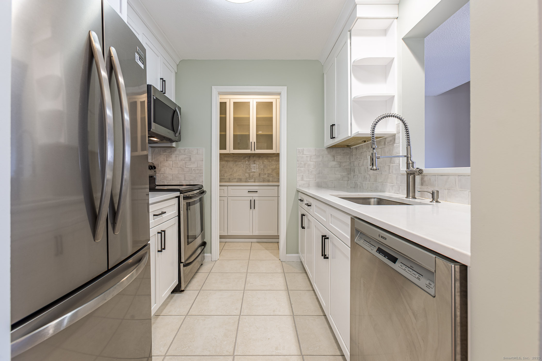 187 Lovers Lane, Unit 61 Torrington, CT 06790 - Photo 7 of 29 a kitchen with stainless steel appliances a refrigerator sink and cabinets