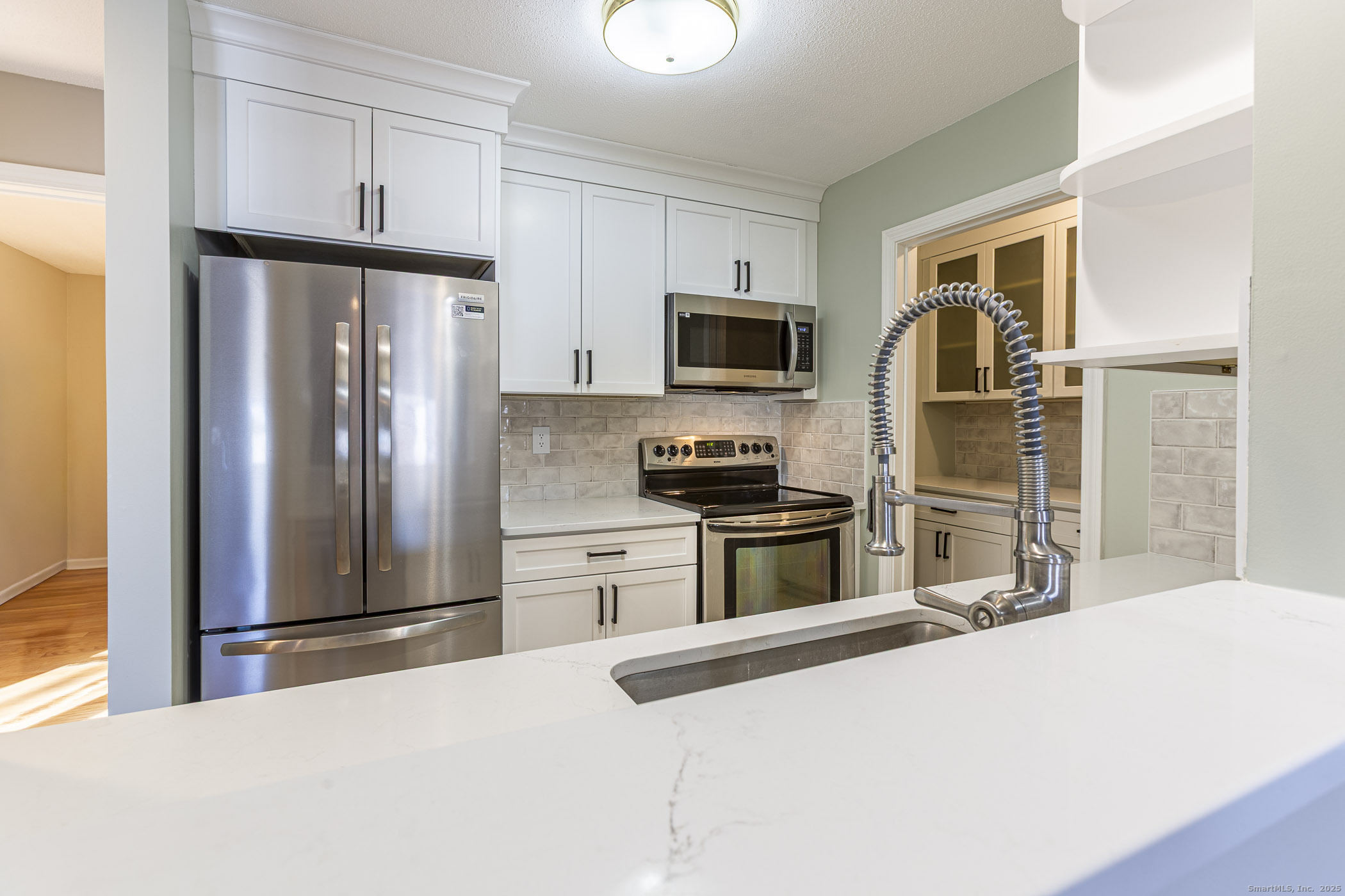 187 Lovers Lane, Unit 61 Torrington, CT 06790 - Photo 10 of 29 a kitchen with granite countertop a refrigerator and a sink