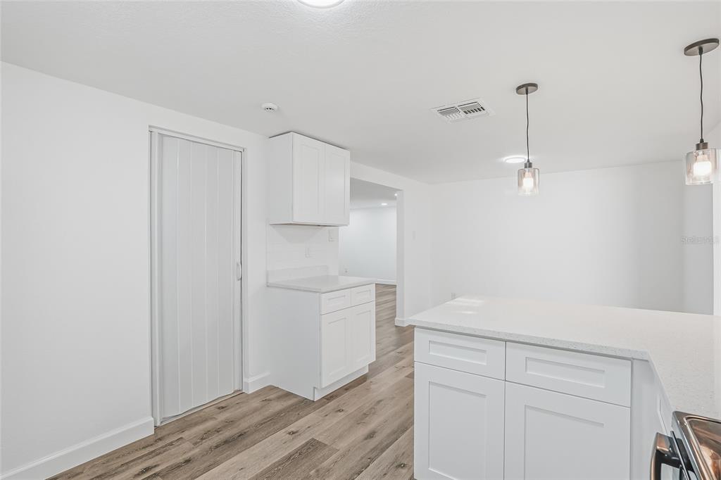 7840 Gulf Way Hudson, FL 34667 - Photo 13 of 37 a hallway with white cabinets and wooden floor