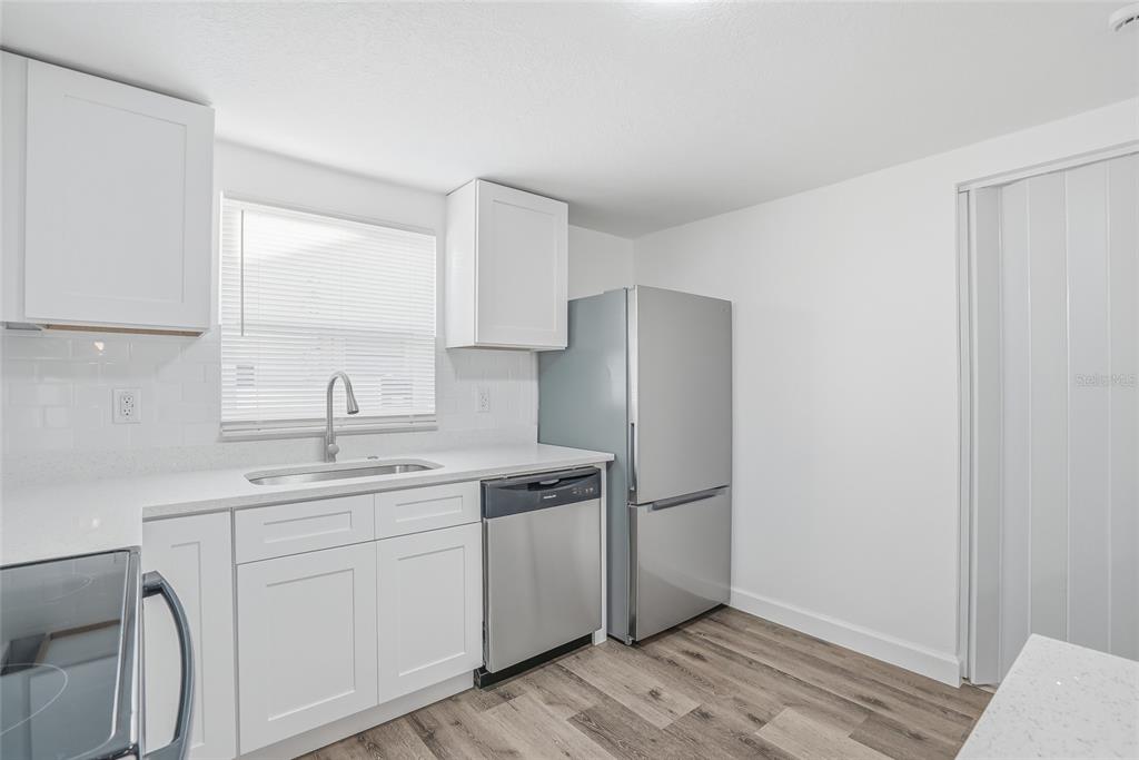 7840 Gulf Way Hudson, FL 34667 - Photo 14 of 37 a kitchen with a sink cabinets stainless steel appliances and a window