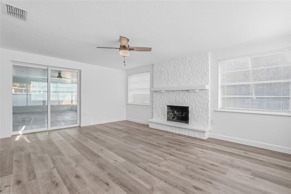 7840 Gulf Way Hudson, FL 34667 - Photo 16 of 37 a view of an empty room with wooden floor fireplace and a window
