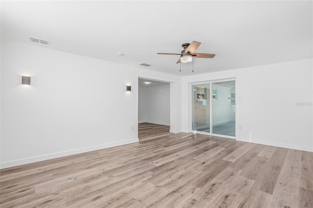 7840 Gulf Way Hudson, FL 34667 - Photo 17 of 37 a view of a room with wooden floor and ceiling fan