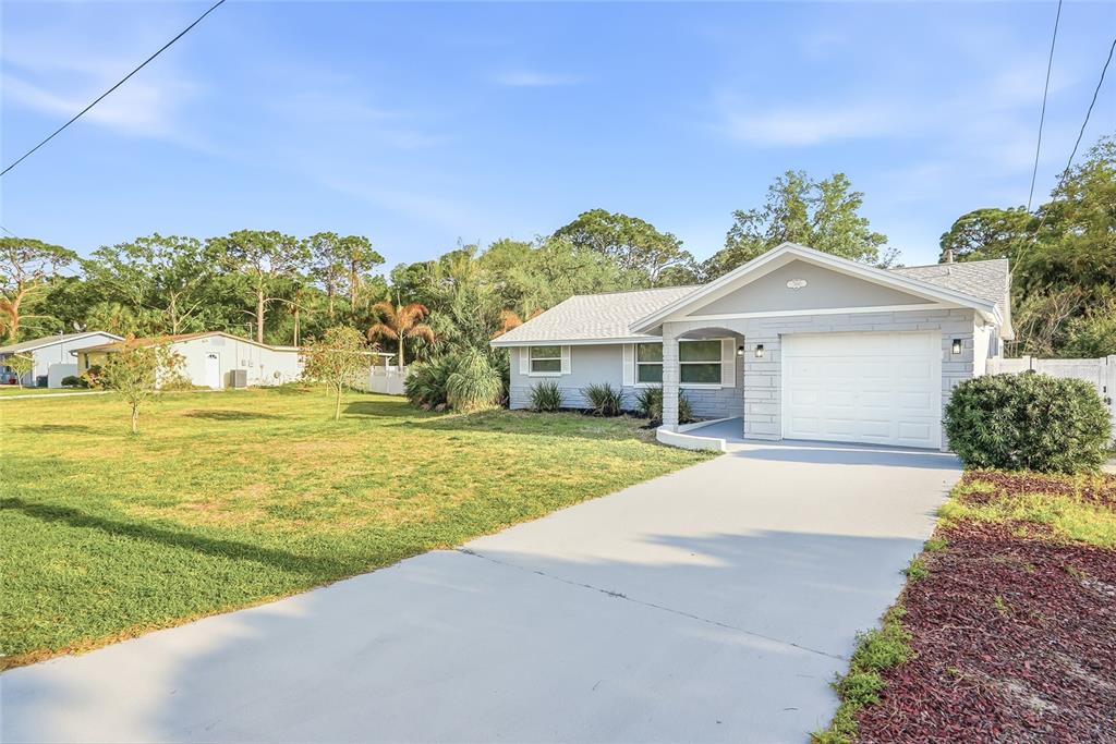 7840 Gulf Way Hudson, FL 34667 - Photo 36 of 37 a front view of a house with a yard and garage