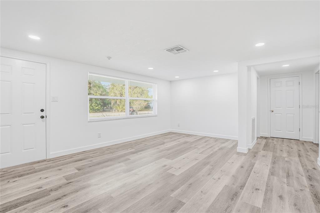7840 Gulf Way Hudson, FL 34667 - Photo 4 of 37 an empty room with wooden floor and windows
