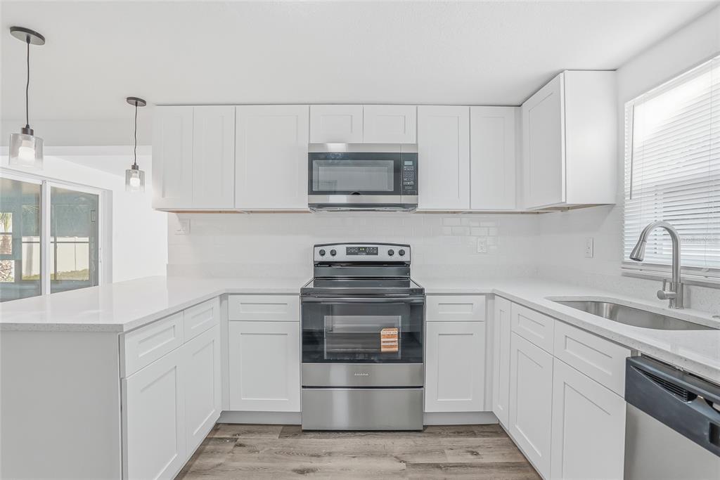 7840 Gulf Way Hudson, FL 34667 - Photo 10 of 37 a kitchen with white cabinets and appliances